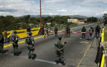 Venezuela's National Guards (bottom) stand in front of Colombia's soldiers at Simon Bolivar international bridge, on the border with Colombia, at San Antonio in Tachira state, Venezuela, August 20, 2015. PHOTO BY REUTERS/Carlos Eduardo Ramirez