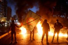 Supporters of Amal movement hold the party's flag near burning tires in Beirut, Lebanon January 29, 2018. PHOTO BY REUTERS/Mohamed Azakir
