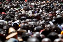 A man wears a mask among fellow supporters as Kenyan opposition leader Raila Odinga (not pictured) takes a symbolic presidential oath of office in Nairobi, Kenya, January 30, 2018. PHOTO BY REUTERS/Baz Ratner