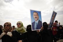 Supporters of Yemen's former President Ali Abdullah Saleh hold posters of Saleh outside the al-Saleh mosque after weekly Friday prayers in Sanaa