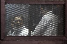 Muslim Brotherhood supporters convicted of playing a role in the killings of 16 policemen in August 2013 during the upheaval that followed the army's ouster of Islamist president Mohamed Mursi, stand behind bars during their trial in Cairo, February 2, 2015. PHOTO BY REUTERS/Mohamed Abd El Ghany