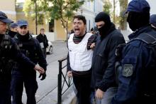 One of the eight men and a woman holding Turkish citizenship, who were arrested on suspected links to a leftist militant group outlawed in Turkey following an operation by Greek security services, is escorted by anti-terrorism police officers to the prosecutor's office in Athens, Greece, December 4, 2017. PHOTO BY REUTERS/Alkis Konstantinidis