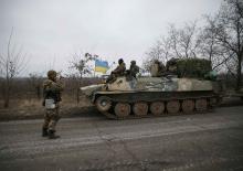 A convoy of Ukrainian armed forces including armoured personnel carriers, military vehicles and cannons prepare to move as they pull back from the Debaltseve region, in Paraskoviyvka, eastern Ukraine, February 26, 2015. PHOTO BY REUTERS/Gleb Garanich