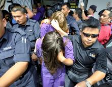 British national Eleanor Hawkins (front), along with three other tourists from Canada and the Netherlands, are escorted by police as they leave a court hearing in Kota Kinabalu, in Malaysia's eastern state of Sabah June 10, 2015. PHOTO BY REUTERS/Mohd Adam Arinin