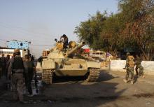 Kurdish "Peshmerga" troops move down a street during an intensive security deployment after clashes with militants of the Islamic State, formerly known as the Islamic State in Iraq and the Levant (ISIL), in Jalawla, Diyala province