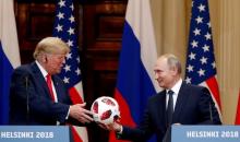 U.S. President Donald Trump receives a football from Russian President Vladimir Putin as they hold a joint news conference after their meeting in Helsinki, Finland, July 16, 2018. PHOTO BY REUTERS/Grigory Dukor