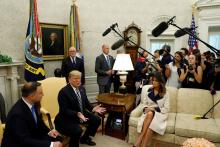 U.S. President Donald Trump speaks next to first lady Melania Trump during a meeting with Poland's President Andrzej Duda (L) in the Oval Office of the White House in Washington, U.S., September 18, 2018. PHOTO BY REUTERS/Kevin Lamarque