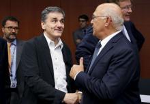 Greek Finance Minister Euclid Tsakalotos listens his French counterpart Michel Sapin (R) during a euro zone finance ministers meeting in Brussels, Belgium, August 14, 2015. PHOTO BY REUTERS/Francois Lenoir