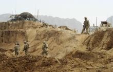 U.S. troops investigate the site of a suicide attack on a NATO base in Zhari, west of Kandahar province
