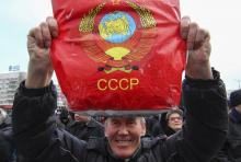 A participant holds a plastic bag with the blazon of USSR during a pro-Russian rally in central Donetsk