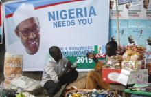 Vendors sell their wares near an election poster of former Nigerian military ruler Muhammadu Buhari before the start of All Progressives Congress (APC) party convention in Lagos, December 10, 2014. PHOTO BY REUTERS/Akintunde Akinleye