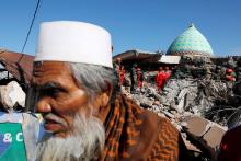 A villager stands as rescue team members and soldiers try to find people trapped inside a mosque after an earthquake hit on Sunday in Pemenang, Lombok Island, Indonesia, August 8, 2018. PHOTO BY REUTERS/Beawiharta