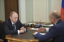 Russian President Vladmir Putin (L) speaks with Finance Minister Anton Siluanov during their meeting at the Novo-Ogaryovo state residence outside Moscow, July 18, 2014. PHOTO BY REUTERS/Alexei Babushkin