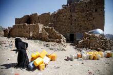 A woman displaced from the Red Sea port city of Hodeidah pulls empty canisters outside her family shelter in Sanaa, Yemen, November 2, 2018. PHOTO BY REUTERS/Mohamed al-Sayaghi