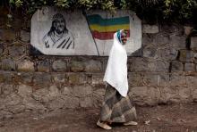 A traditionally-dressed Ethiopian woman walks past a mural depicting Ethiopia's Emperor Tewodros II in Addis Ababa, Ethiopia. PHOTO BY REUTERS/Andrew Heavens