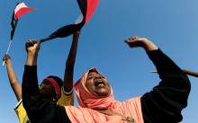 A Sudanese woman chants slogans and waves national flag in celebration following Sudan's ruling military council and a coalition of opposition and protest groups reached an agreement to share power during a transition period leading to elections, along the streets of Khartoum, Sudan, July 5, 2019. PHOTO BY REUTERS/Mohamed Nureldin Abdallah