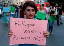 A woman carries a placard during a demonstration against sectarianism, also calling for abolishing curfews put on Syrian refugees in Beirut, Lebanon, July 18 , 2016. PHOTO BY REUTERS/Mohamed Azaki