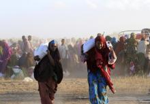 Displaced Somali women leave with food rations from a distribution centre after moving to higher ground due to flooding in areas around Jowhar, a town north of Somalia's capital Mogadishu