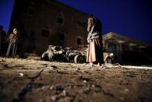 An armed man looks at the wreckage of a car at the site of a car bomb attack in Yemen's capital Sanaa, June 17, 2015. PHOTO BY REUTERS/Khaled Abdullah