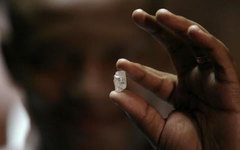 A visitor holds a 17 carat diamond at a Petra Diamonds mine, January 22,2009. PHOTO BY REUTERS/Siphiwe Sibeko