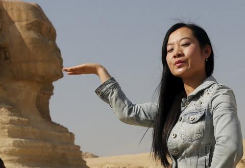 A Chinese tourist poses for a photo in front of the Sphinx at the Giza Pyramids on the outskirts of Cairo, Egypt, March 2, 2016. PHOTO BY REUTERS/Amr Abdallah Dalsh