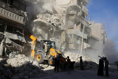A front loader removes debris in a damaged site after airstrikes on the rebel held Tariq al-Bab neighbourhood of Aleppo, Syria, September 24, 2016. PHOTO BY REUTERS/Abdalrhman Ismail