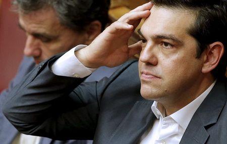 Greek Prime Minister Alexis Tsipras (R) reacts as he sits next to Finance Minister Euclid Tsakalotos during a parliamentary session in Athens, Greece, July 16, 2015. PHOTO BY REUTERS/Christian Hartmann