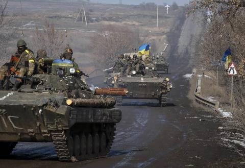 Members of the Ukrainian armed forces ride on armoured personnel carriers (APC) near Debaltseve, eastern Ukraine, February 12, 2015. PHOTO BY REUTERS/Gleb Garanich