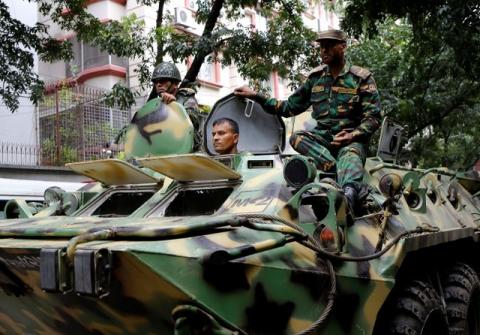 Army soldiers atop an armored military vehicle drive near the Holey Artisan restaurant after Islamist militants attacked the upscale cafe in Dhaka, Bangladesh, July 2, 2016. PHOTO BY REUTERS/Mohammd Ponir Hossain