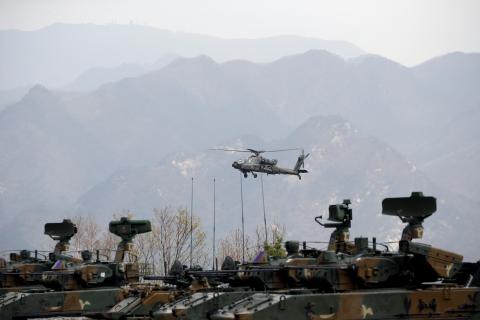 A U.S. Army's AH-64 Apache helicopter flies over amoured vehicles, during a U.S.-South Korea joint live-fire military exercise, at a training field, near the demilitarized zone, separating the two Koreas in Pocheon, South Korea, April 21, 2017. PHOTO BY REUTERS/Kim Hong-Ji