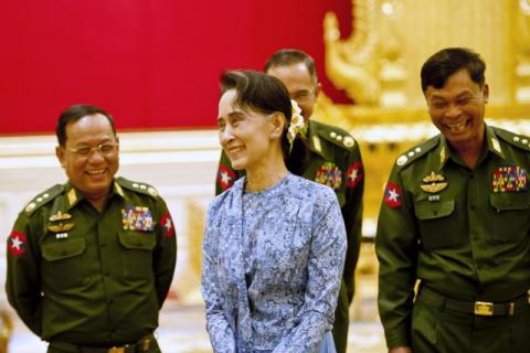 Myanmar's NLD party leader Aung San Suu Kyi smiles with army members during the handover ceremony of outgoing President Thein Sein and new President Htin Kyaw at the presidential palace in Naypyidaw, March 30, 2016. PHOTO BY REUTERS/Ye Aung Thu