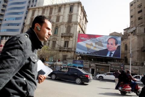 People walk by a poster of Egypt's President Abdel Fattah al-Sisi from the campaign titled “Alashan Tabneeha” (So You Can Build It) for the upcoming presidential election in Cairo, Egypt, January 22, 2018. PHOTO BY REUTERS/Amr Abdallah Dalsh