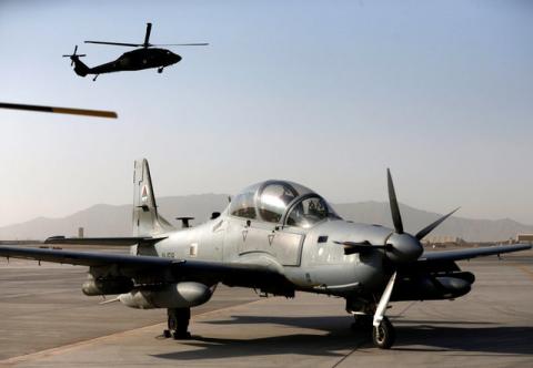 A Blackhawk helicopter flies above a parked A-29 Super Tucano aircraft, during a handover ceremony of Blackhawk helicopters from U.S. to the Afghan forces, at the Kandahar Air base, Afghanistan October 7, 2017. PHOTO BY REUTERS/Omar Sobhani