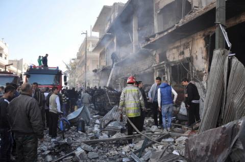Civil Defence members work at the site of two bomb explosions in the Syrian city of Homs, Syria, in this handout picture provided by SANA, December 28, 2015. PHOTO BY REUTERS/SANA