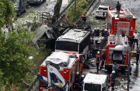 Forensic experts (L) and firefighters stand beside a Turkish police bus which was targeted in a bomb attack in a central Istanbul district, Turkey, June 7, 2016. PHOTO BY REUTERS/Osman Orsal