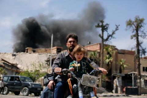 A man and a boy ride a motorbike at the city of Douma in Damascus, Syria, April 16, 2018. PHOTO BY REUTERS/Omar Sanadiki