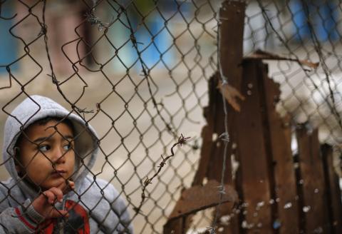 A Palestinian boy looks through a fence near his family's house (not seen), that witnesses said was damaged by Israeli shelling during a 50-day war last summer, in the east of Gaza City, January 7, 2015. PHOTO BY REUTERS/Suhaib Salem
