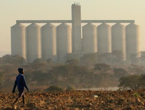 A boy walks on a prepared field in front of grain silos in the farming area of Chinhoyi, Zimbabwe, July 26, 2017. PHOTO BY REUTERS/Philimon Bulawayo