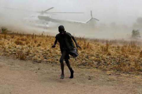 A boy moves away as a United Nations World Food Programme (WFP) helicopter lands in Rubkuai village, Unity State, northern South Sudan, February 18, 2017. PHOTO BY REUTERS/Siegfried Modola