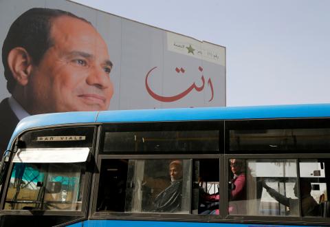 People ride on a bus as posters with Egypt's President Abdel Fattah al-Sisi are displayed during preparations for the presidential election in Cairo, Egypt, March 25, 2018. PHOTO BY REUTERS/Ammar Awad