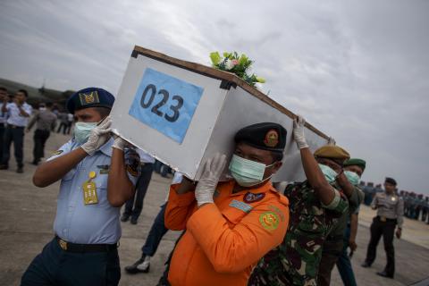 Indonesian military personnel carry a casket containing the remains of a passenger onboard AirAsia flight QZ8501, recovered off the coast of Borneo, at a military base in Surabaya, January 3, 2015. PHOTO BY REUTERS/Athit Perawongmetha