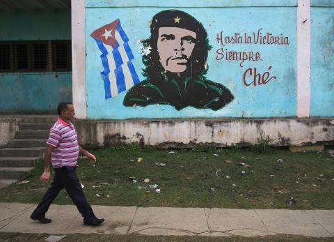 A man walks past near an image of revolutionary hero Ernesto "Che" Guevara in Havana, December 27, 2014. PHOTO BY REUTERS/Stringer
