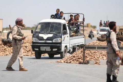 Syria Democratic Forces (SDF) fighters man a checkpoint as civilians on pick-up trucks evacuate from the southern districts of Manbij city after the SDF advanced into it in Aleppo Governorate, Syria, July 1, 2016. PHOTO BY REUTERS/Rodi Said