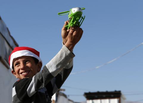 A Syrian refugee child plays with his Christmas gift from SAWA, a non-governmental organisation, in Bar-Elias in the Bekaa valley, December 24, 2014. PHOTO BY REUTERS/Jamal Saidi