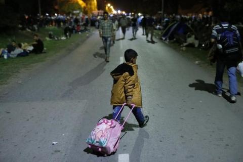 A migrant child crosses the street with a luggage in Tovarnik, Croatia, September 17, 2015. PHOTO BY REUTERS/Antonio Bronic