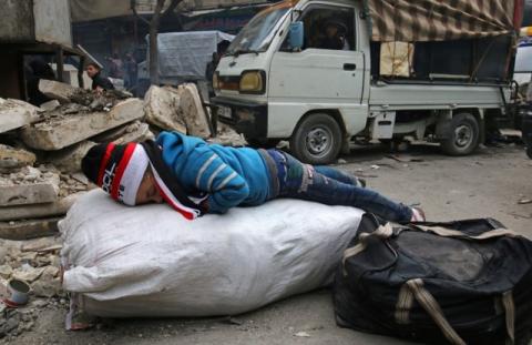 A child sleeps while waiting to be evacuated with others from a rebel-held sector of eastern Aleppo, Syria, December 17, 2016. PHOTO BY REUTERS/Abdalrhman Ismail