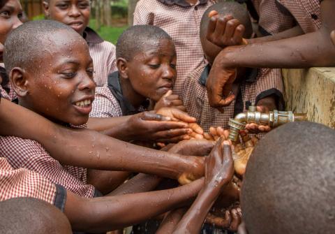 Schoolchildren jostle for water from a project supported by former Global Ambassador for World Vision, Meghan Markle, in Gatsibo district, Rwanda, April 27, 2018.PHOTO BY REUTERS/Jean Bizimana