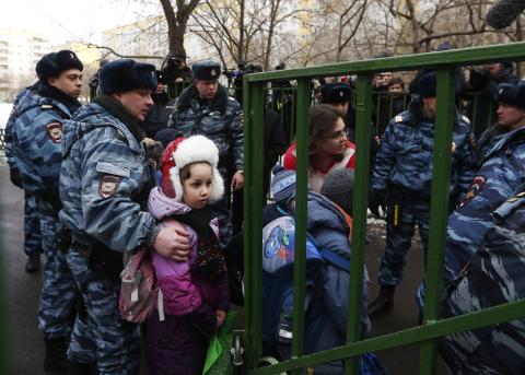 Children walk out of the premises of a high school, where a shooting incident has occurred, on the outskirts of Moscow