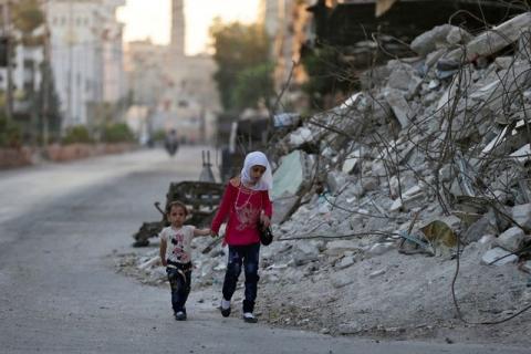 Children walk past the rubble of damaged buildings on the first day of the Muslim holiday of Eid al-Fitr, which marks the end of the holy month of Ramadan, in the rebel held Douma neighbourhood of Damascus, Syria, July 6, 2016. PHOTO BY REUTERS/Bassam Khabieh