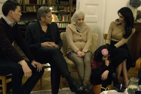 IRC President and CEO David Miliband (L) George Clooney (2nd L), and Amal Clooney (R) meet with Syrian refugees Mona and her daughter, 11-year-old Joudi, in Berlin, Germany, February 12, 2016. PHOTO BY  REUTERS/Jeffry Ruigendijk